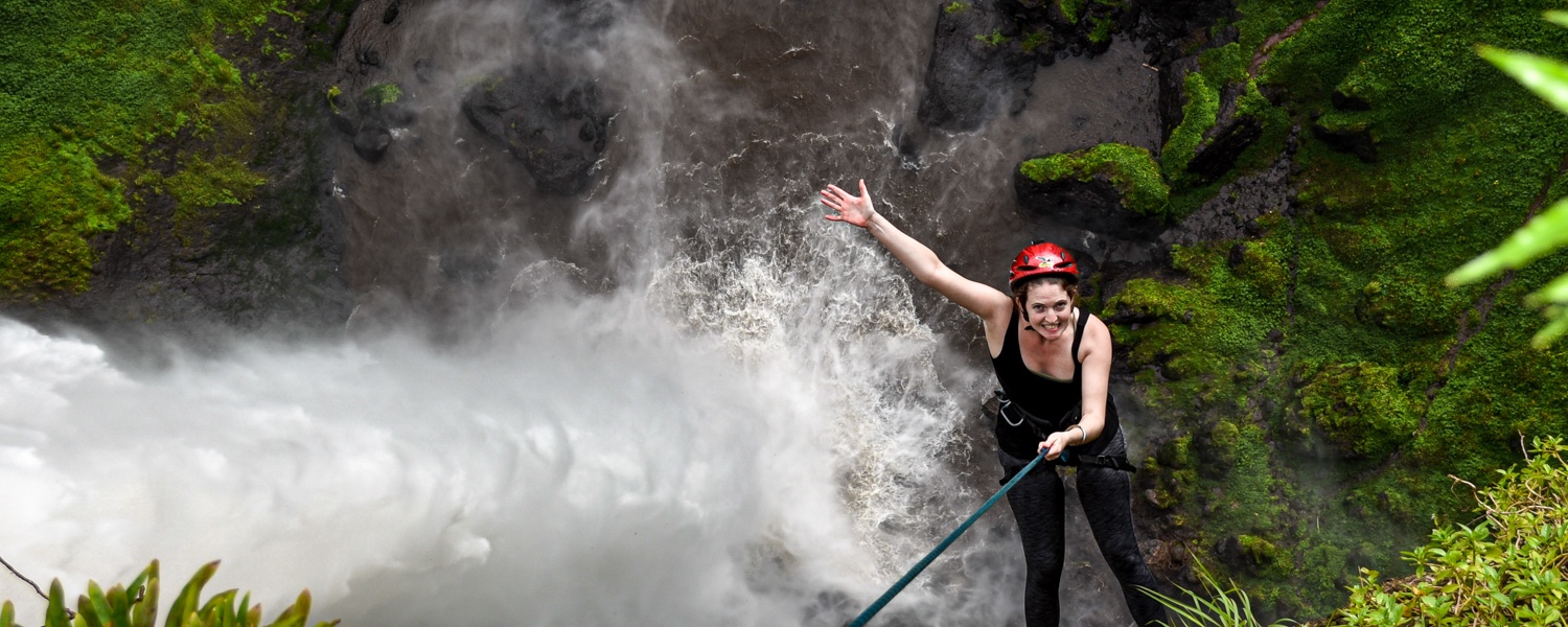 Abseiling down the rock face at Sipi Falls waterfalls, Uganda